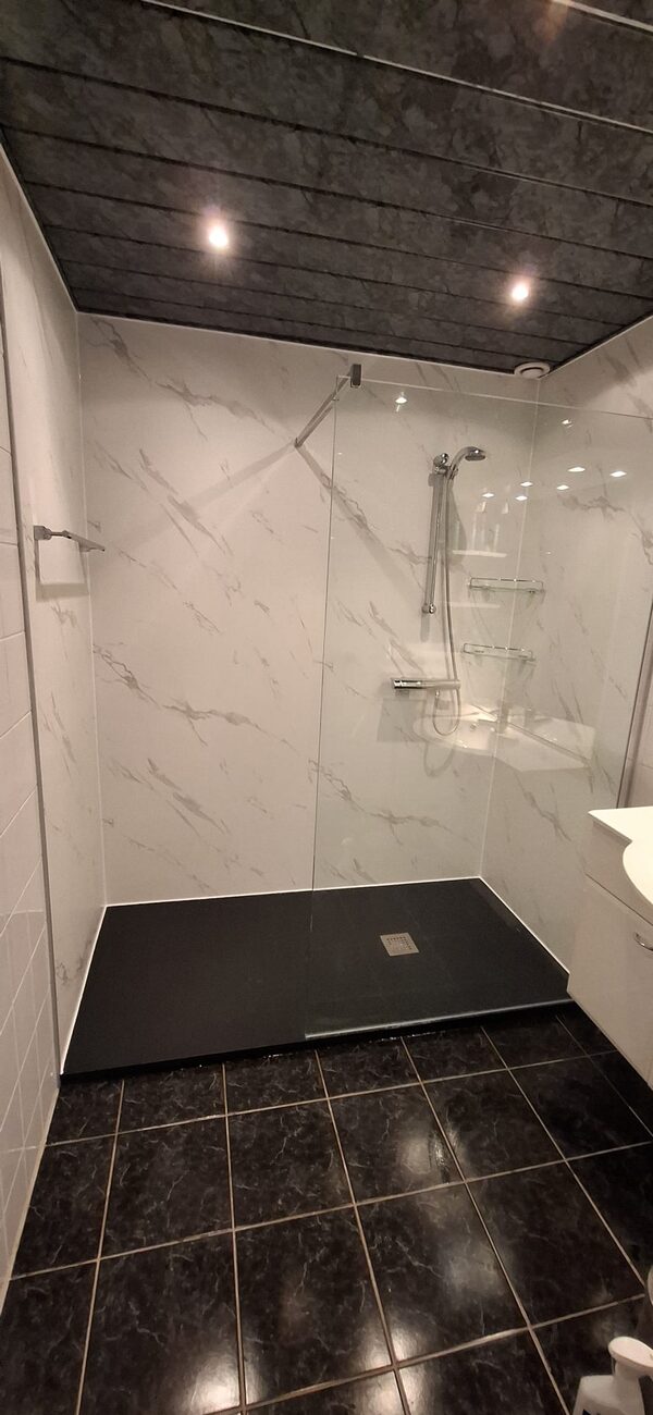 Moderne badkamer met inloopdouche, witte marmerlook wanden en donkere vloer